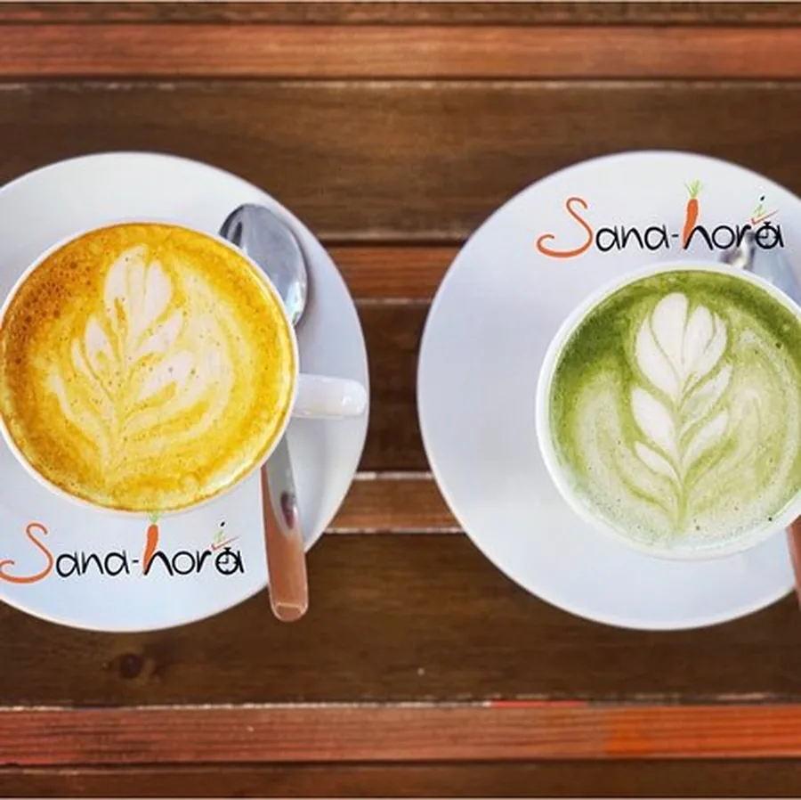 Latte de cúrcuma y latte de matcha con arte latte, vistos desde arriba